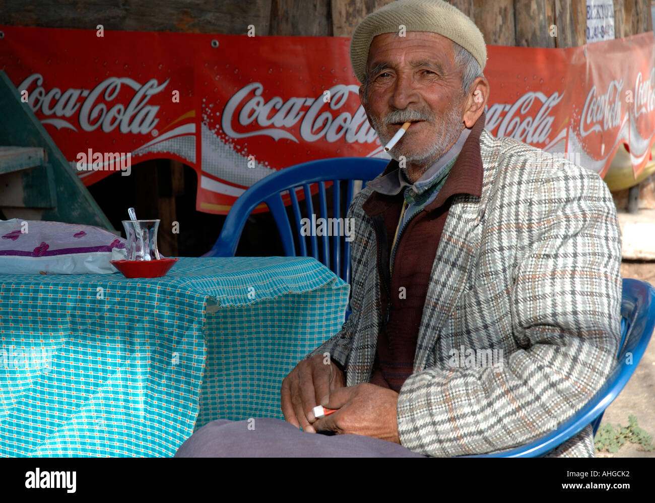 Portrait of elderly man smoking and drinking tea with  at cafe bar in Southern Turkish village. Stock Photo