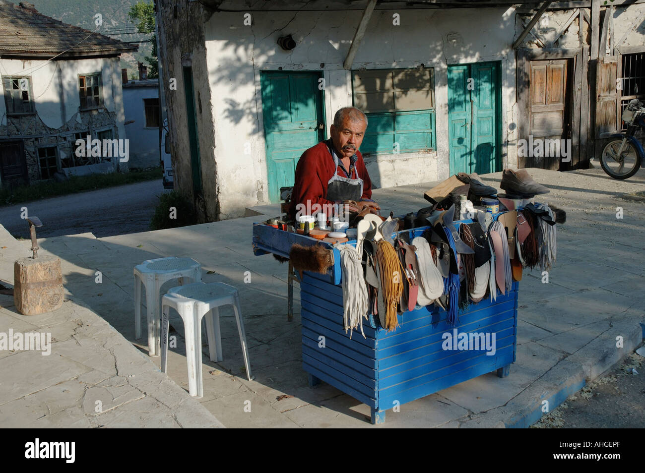 Cobbler repairing shoes in main square of small rural village in Anatolia in Southern Turkey Stock Photo