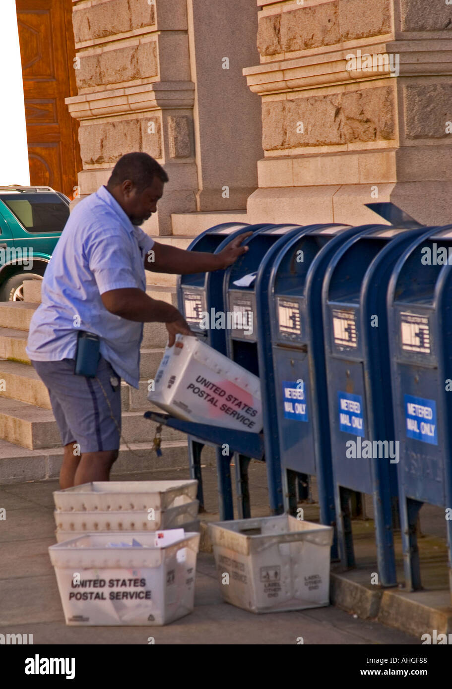 African American US Postal Worker Empties Mail Boxes in Downtown Charleston South Carolina USA Stock Photo