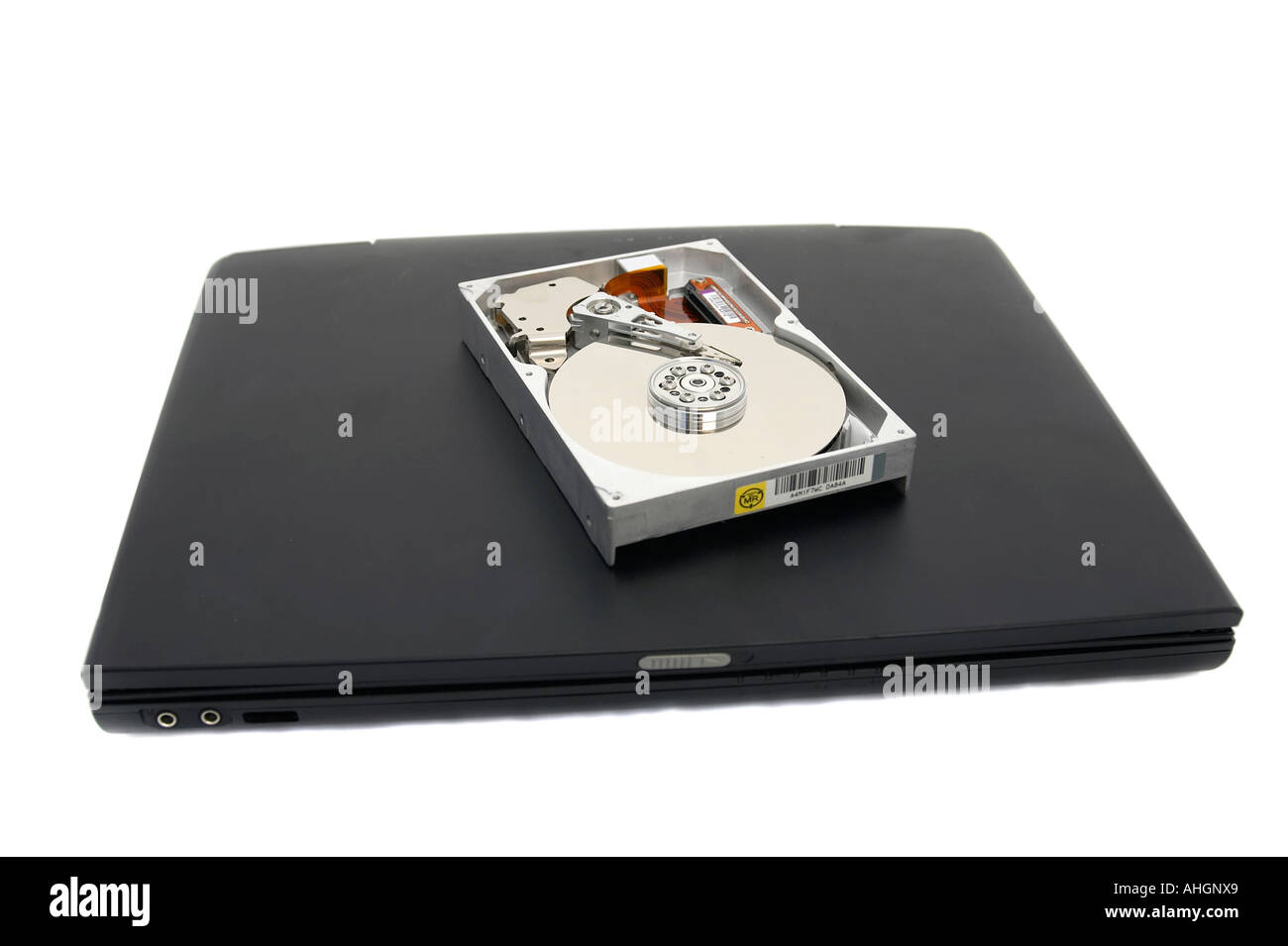 Laptop and open broken hard disc against a white background Stock Photo