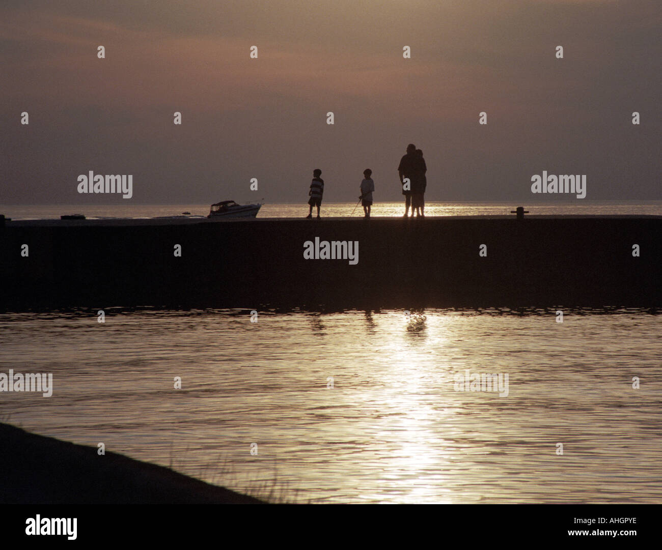 Family in Silhouette on Lake Huron Pier at Sunset Ontario Canada Stock Photo