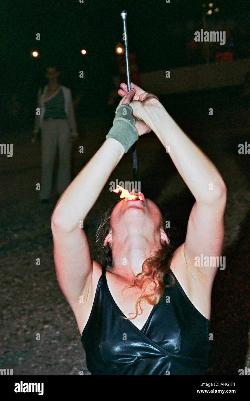 A female juggler of 20 swallowing fire Stock Photo