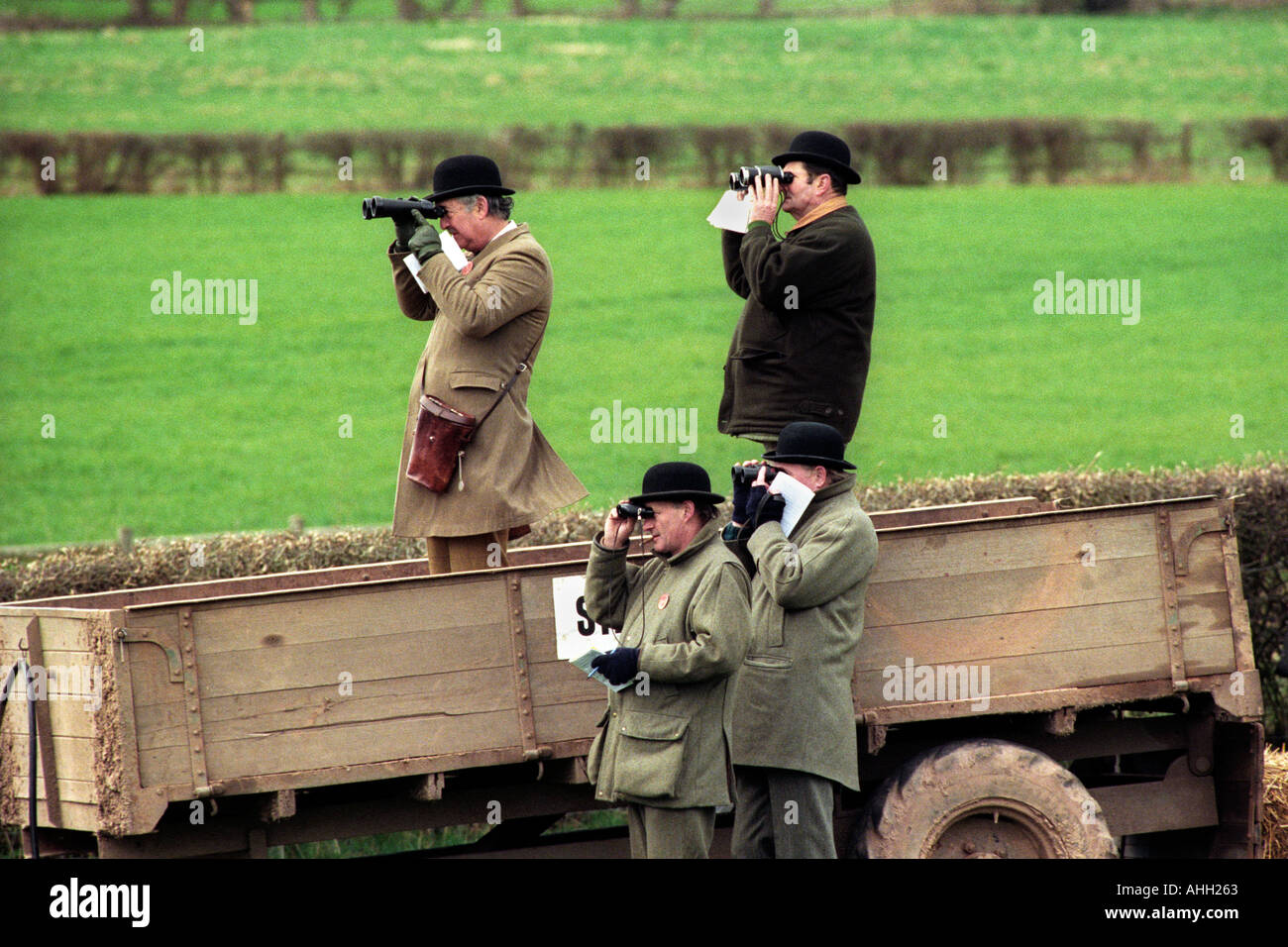 Horse racing stewards stand in a farm trailer to watch the racing at