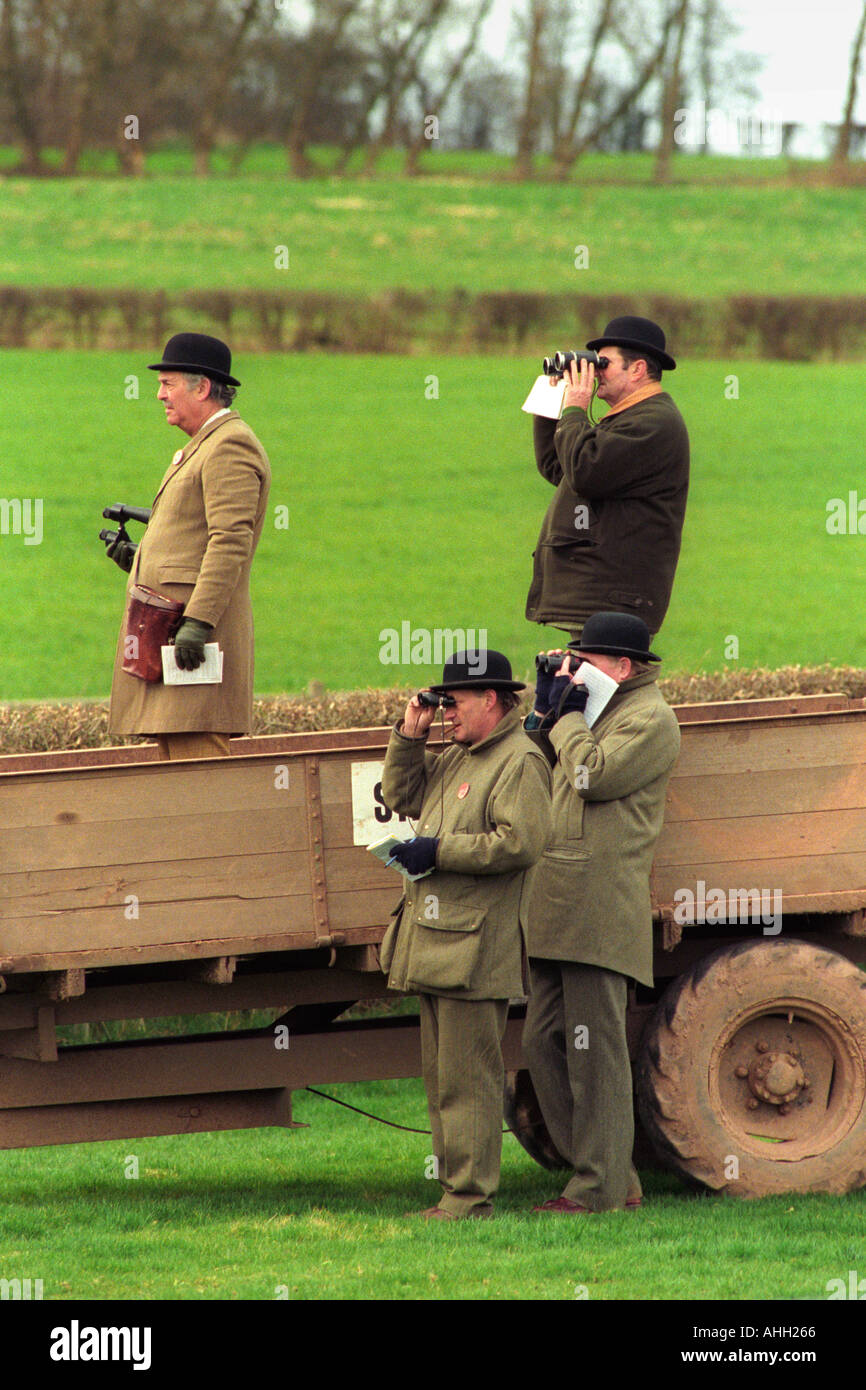 Horse racing stewards stand in a farm trailer to watch the racing at