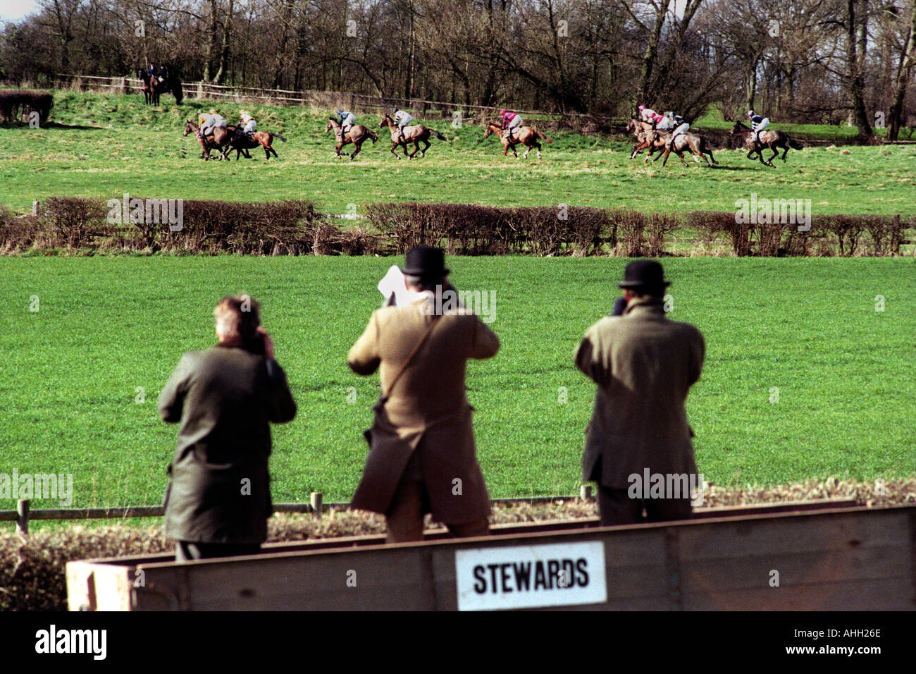 Horse racing stewards stand in a farm trailer to watch the racing at
