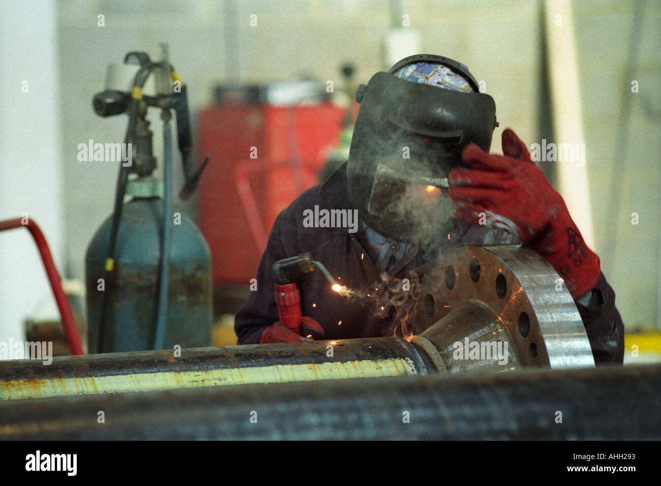 Welder working on a pipe for the oil industry in Milford Haven Pembrokeshire West Wales UK Stock Photo