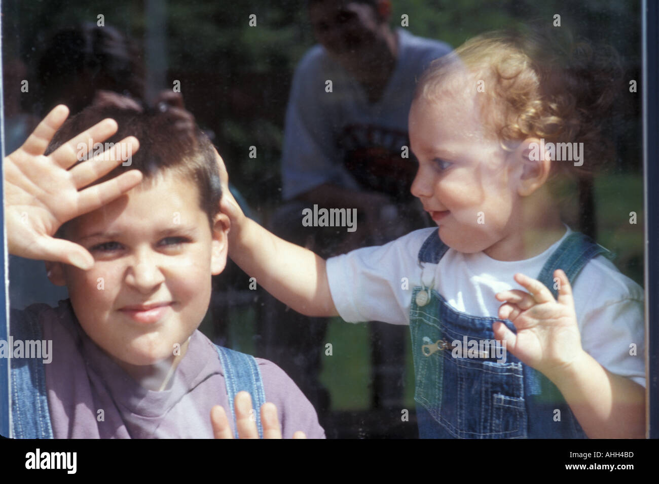 Young Boys behind Glass Door Stock Photo