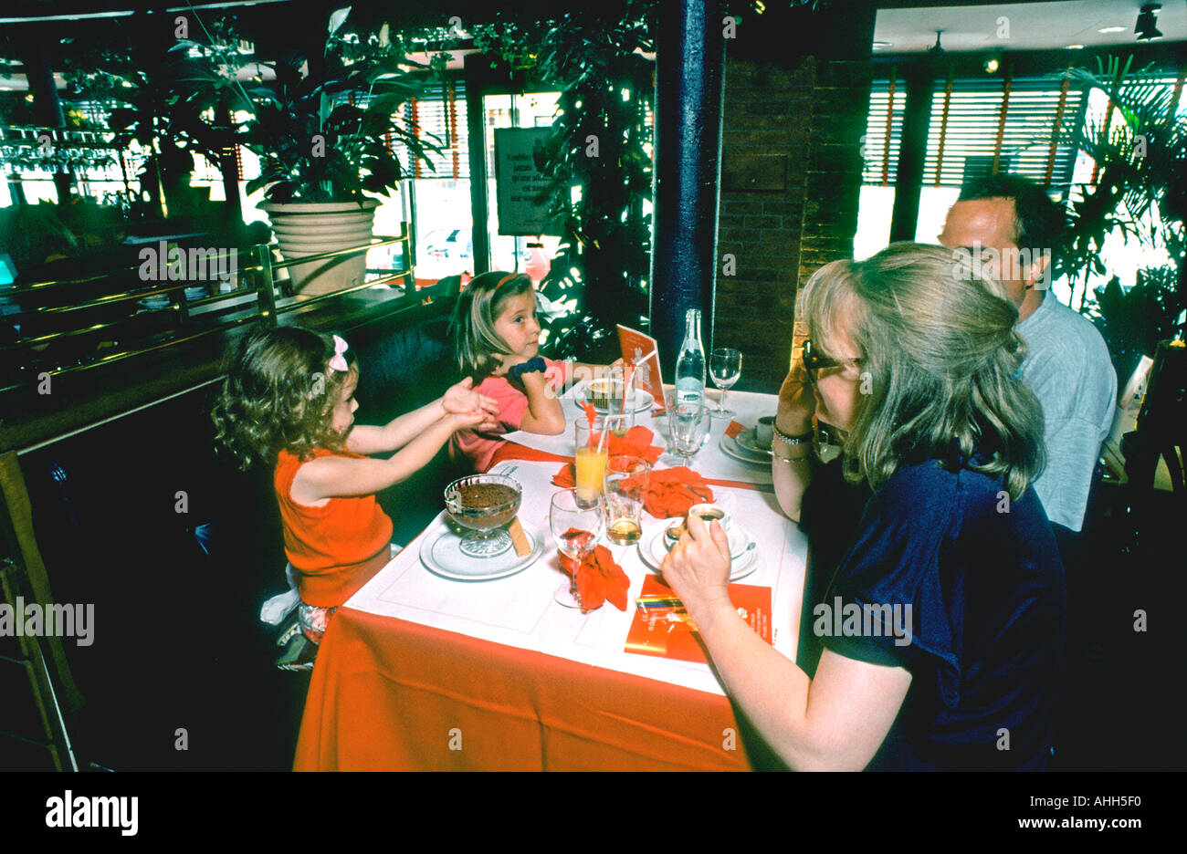 Paris France, middle class family at the restaurant Parents with Children, Two Girls Sharing Meals, Dining, in a French Brasserie Restaurant, Inside Stock Photo