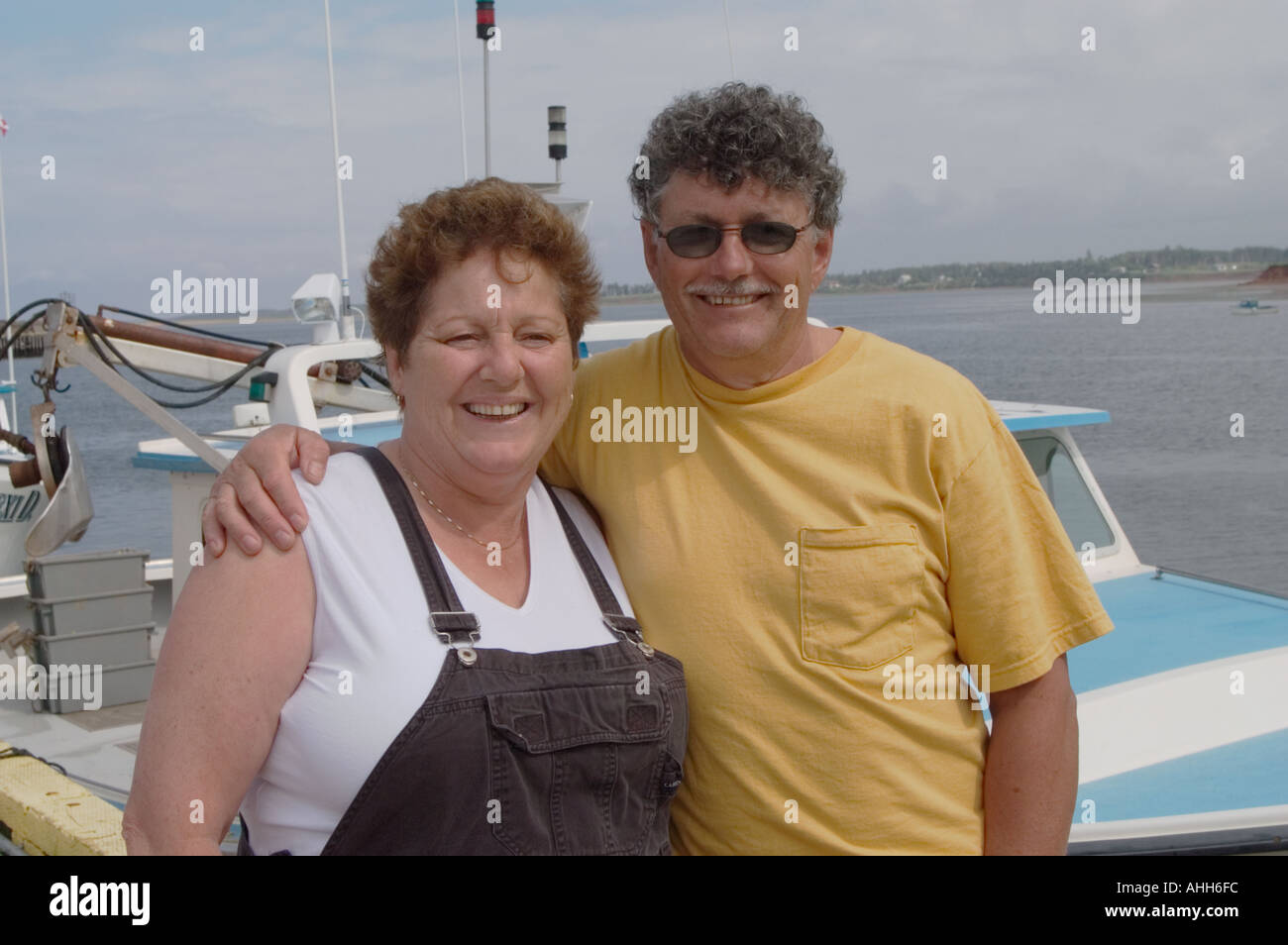 Mussel farmers husband and wife in front of their boat Cricker Crunch Rustico Harbor Prince Edward Island Canada Stock Photo