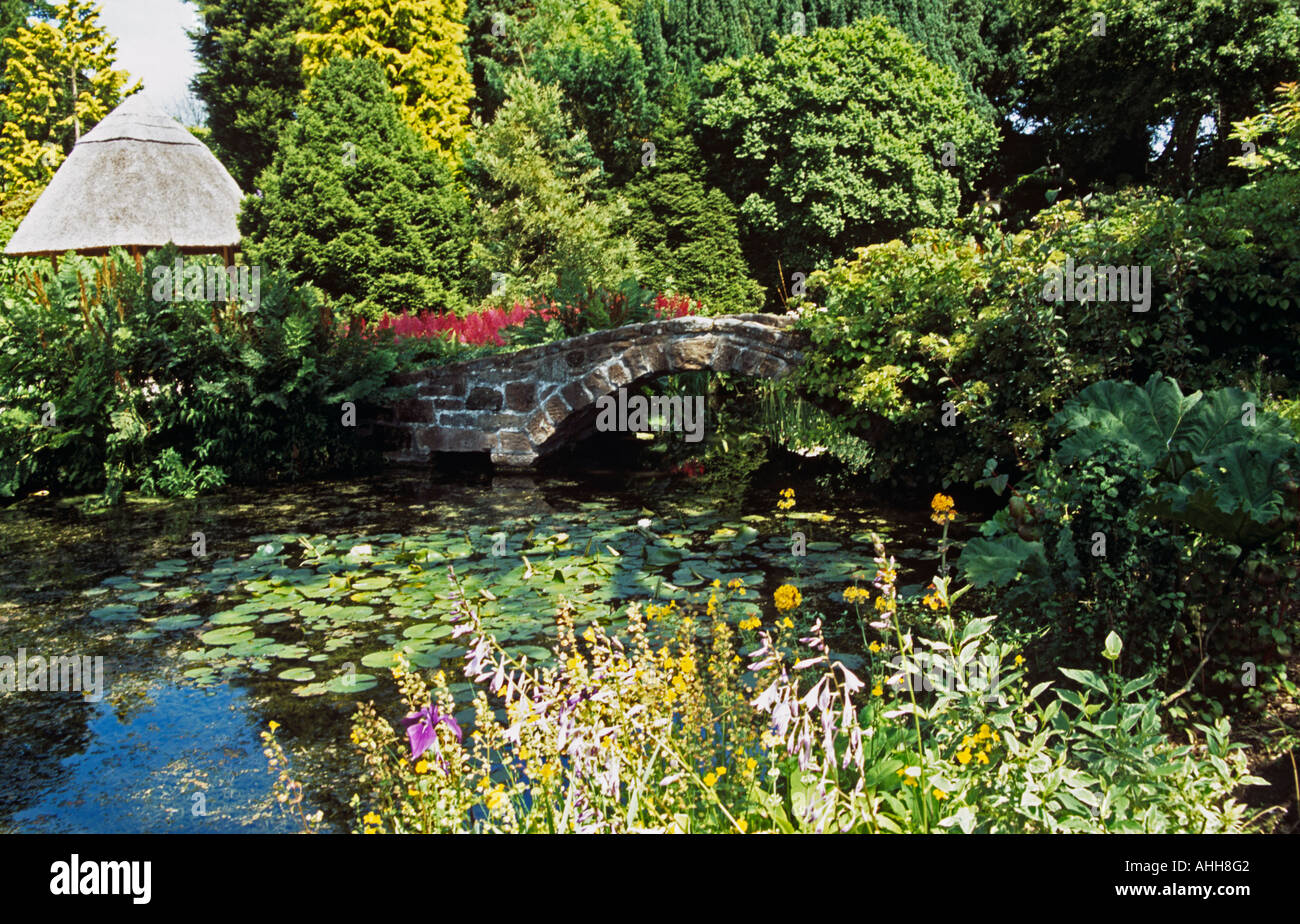 NESS GARDENS NESTON CHESHIRE UK July The water garden area with a stone bridge over the pond of