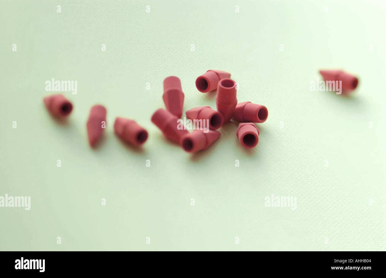 many pencil erasers form a design or pattern on simple surface Stock Photo