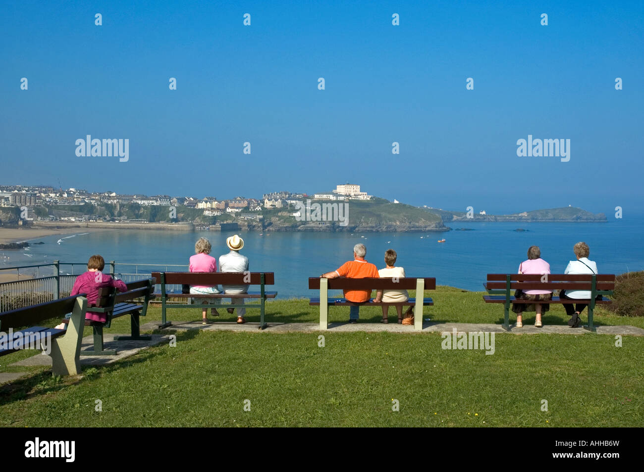 tourists sitting on seats overlooking the bay at newquay,cornwall,england Stock Photo