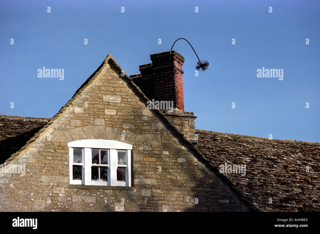 A chimney sweep's brush protruding from a chimney stack Stock Photo