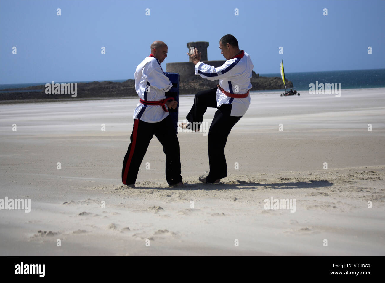 Free Style Beach Karate Jersey ,Channel Islands UK on Five Mile Beach at St Ouen's and La Rocco Tower in the background Stock Photo