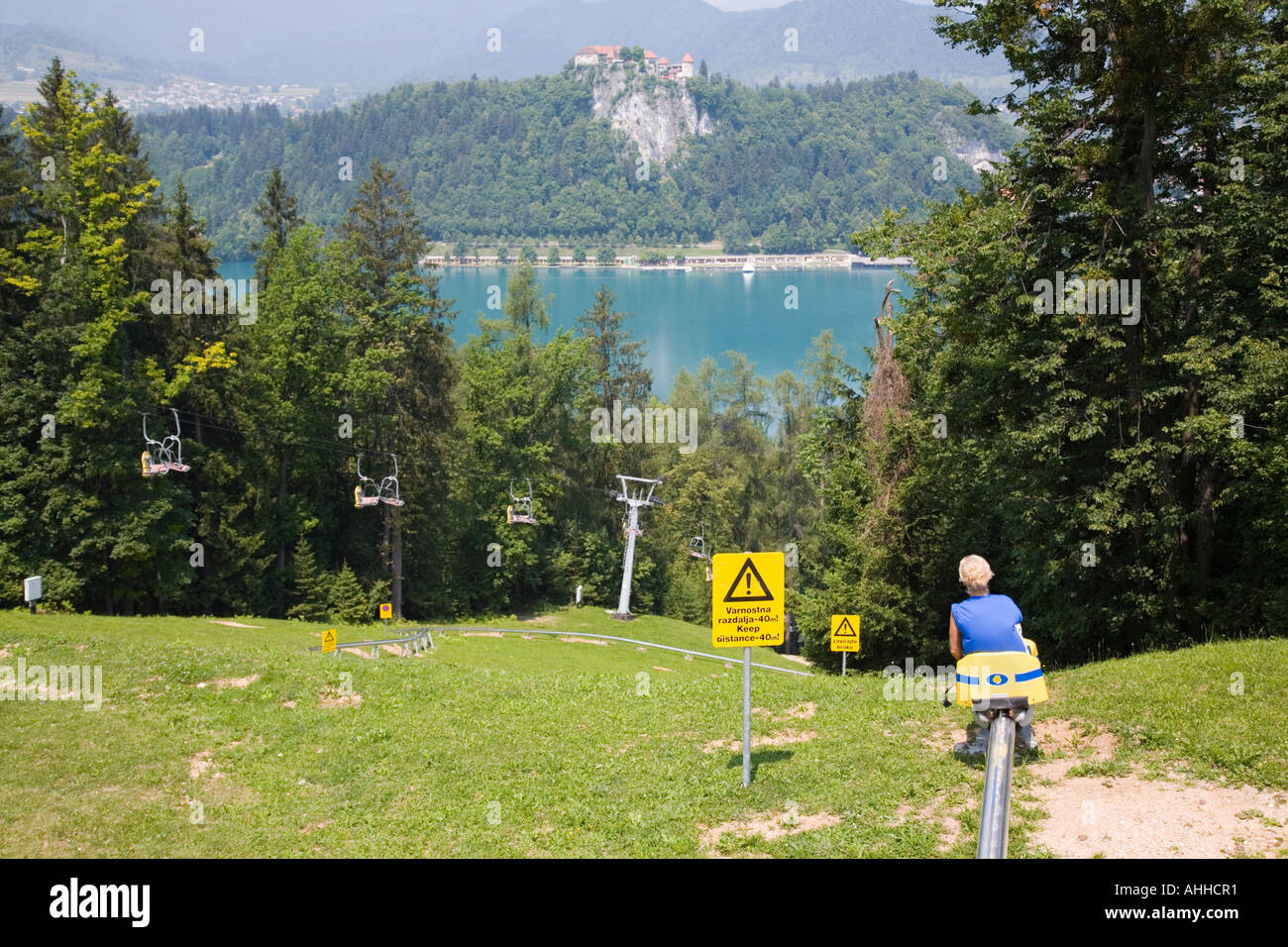 Lady on summer toboggan ride down Straza ski slope above Lake Bled Bled