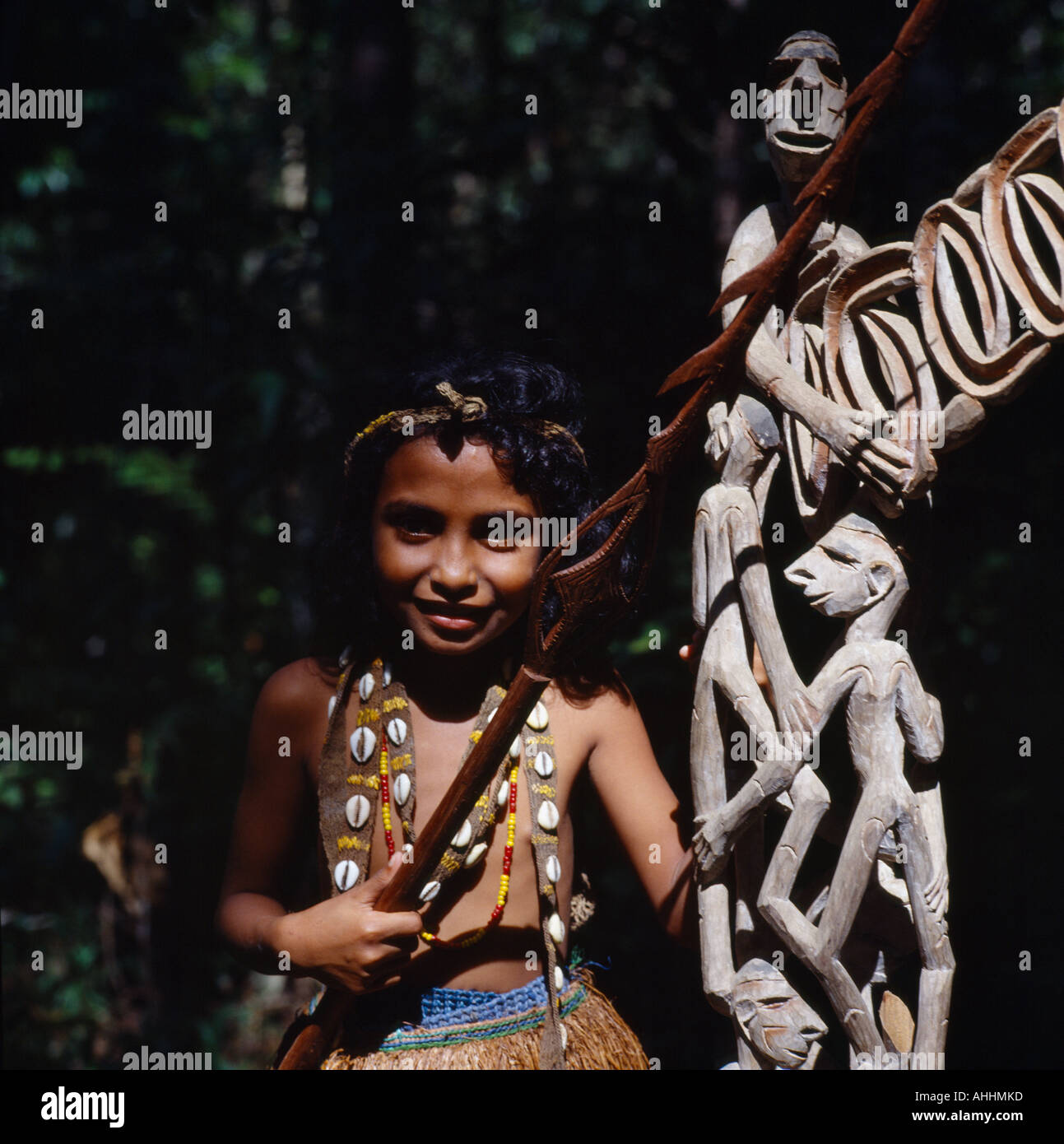 INDONESIA Southeast Asia Irian Jaya Sorong Young girl beside traditional wooden carvings. Stock Photo