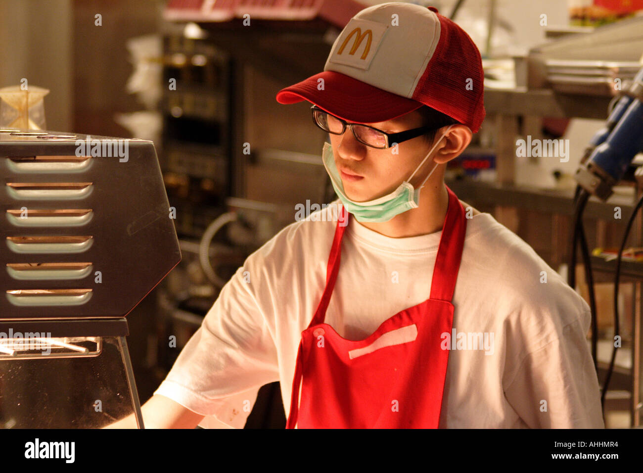 McDonalds Employee in front of the French Fry Frier in Hong Kong Stock Photo