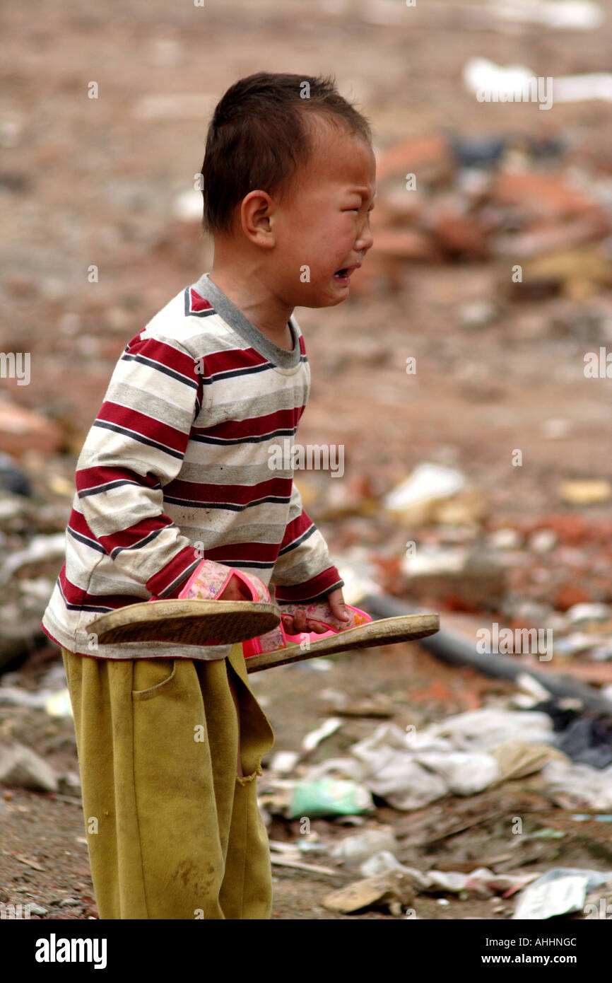 Small Barefoot Homeless Chinese Boy Crying in a Vacant Lot, Shenzhen, China Stock Photo