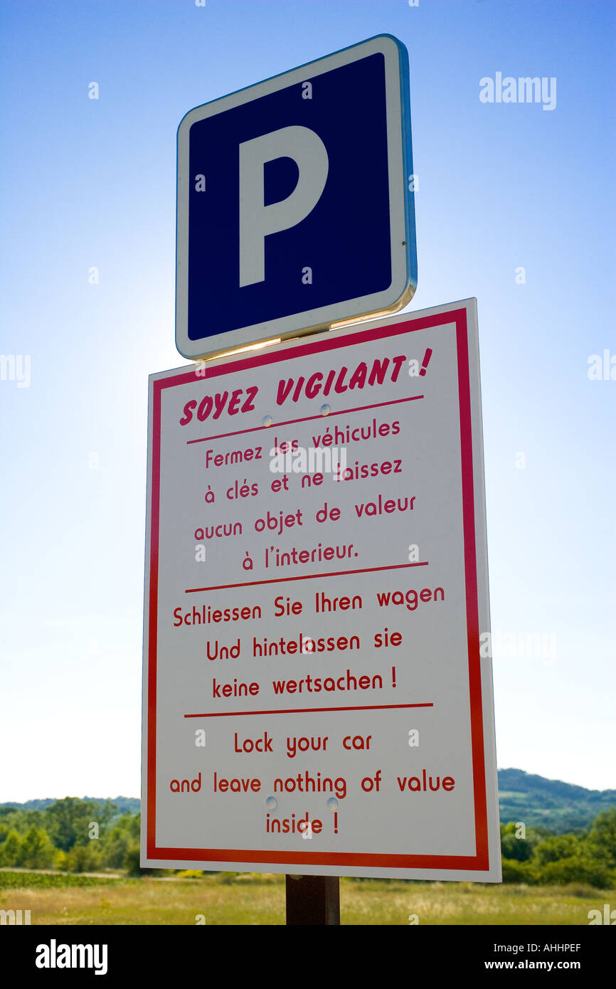 Multilingual rural car crime prevention area warning sign, cars parking, Provence, France, Europe Stock Photo