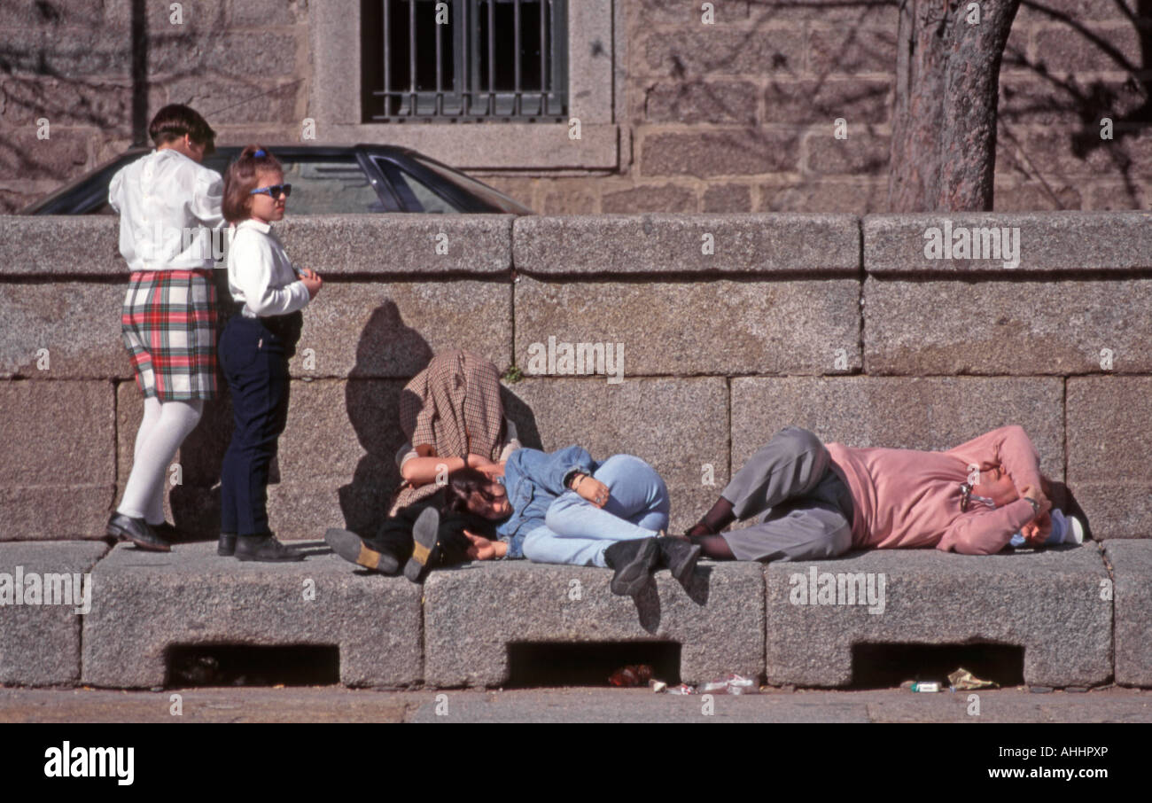 El Escorial, Spain. Tourist family asleep on stone bench Stock Photo