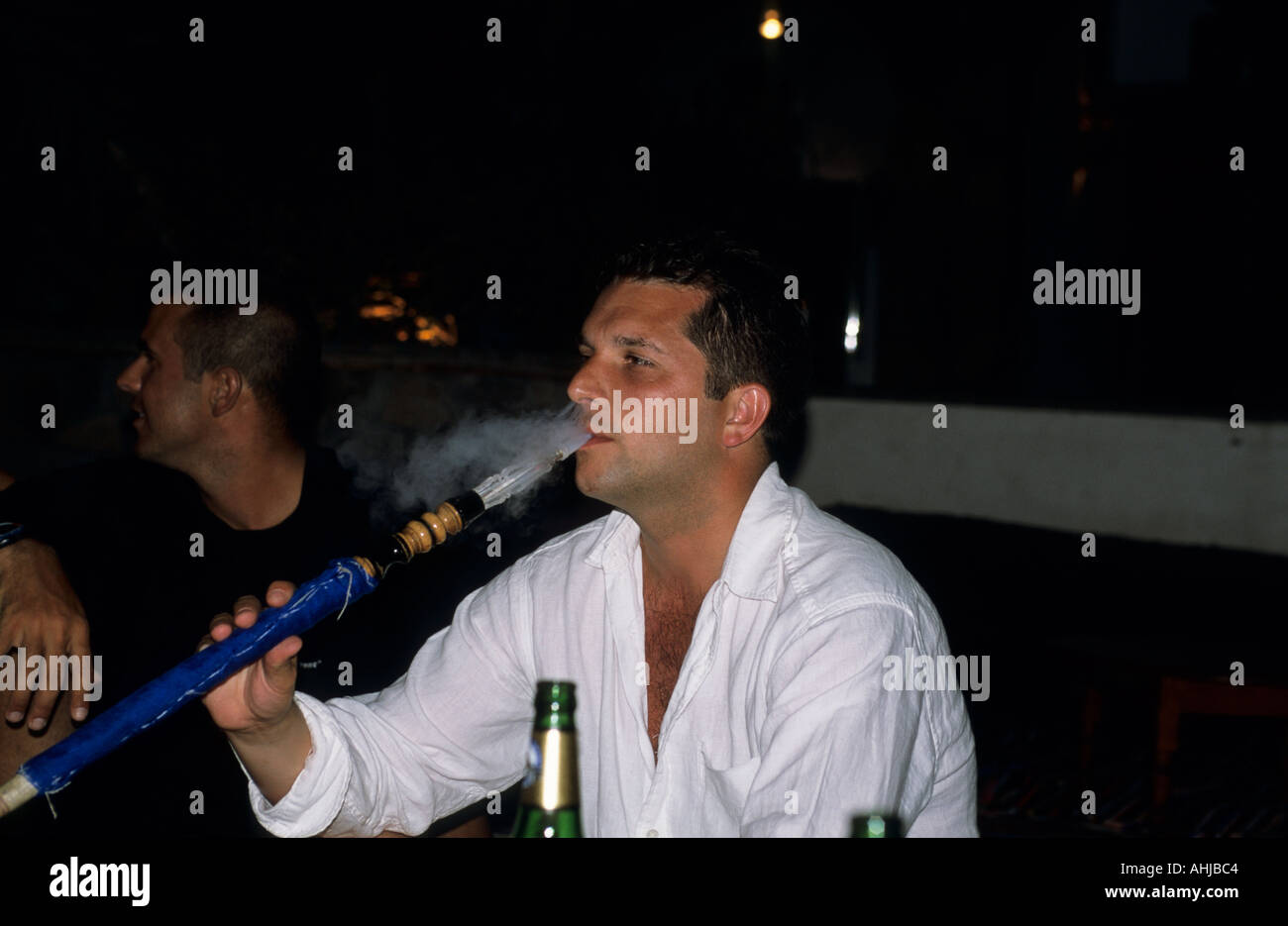 where to buy cigarettes in sharm el sheikh Tourist wearing white shirt and smoking traditional shisha pipe in a bar. Sharm  el Sheikh, Egypt Stock Photo