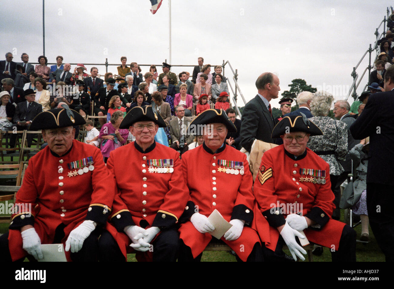 Four Chelsea Pensioners in full ceremonial uniform in front of crowd at formal event at Royal Military Academy Sandhurst. Sandhurst, UK. Stock Photo