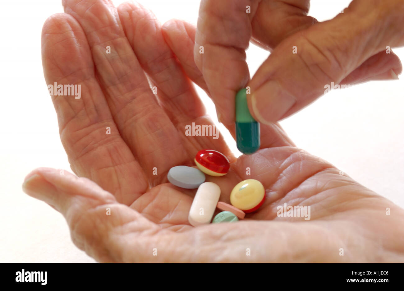 old woman putting pills into hand Stock Photo