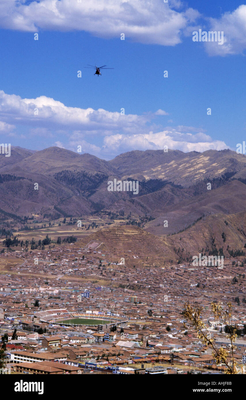 View of Cusco from Sacsayhuaman with Estadio Inca Garcilaso de la Vega football stadium, mountains in background and helicopter above. Cusco, Peru. Stock Photo