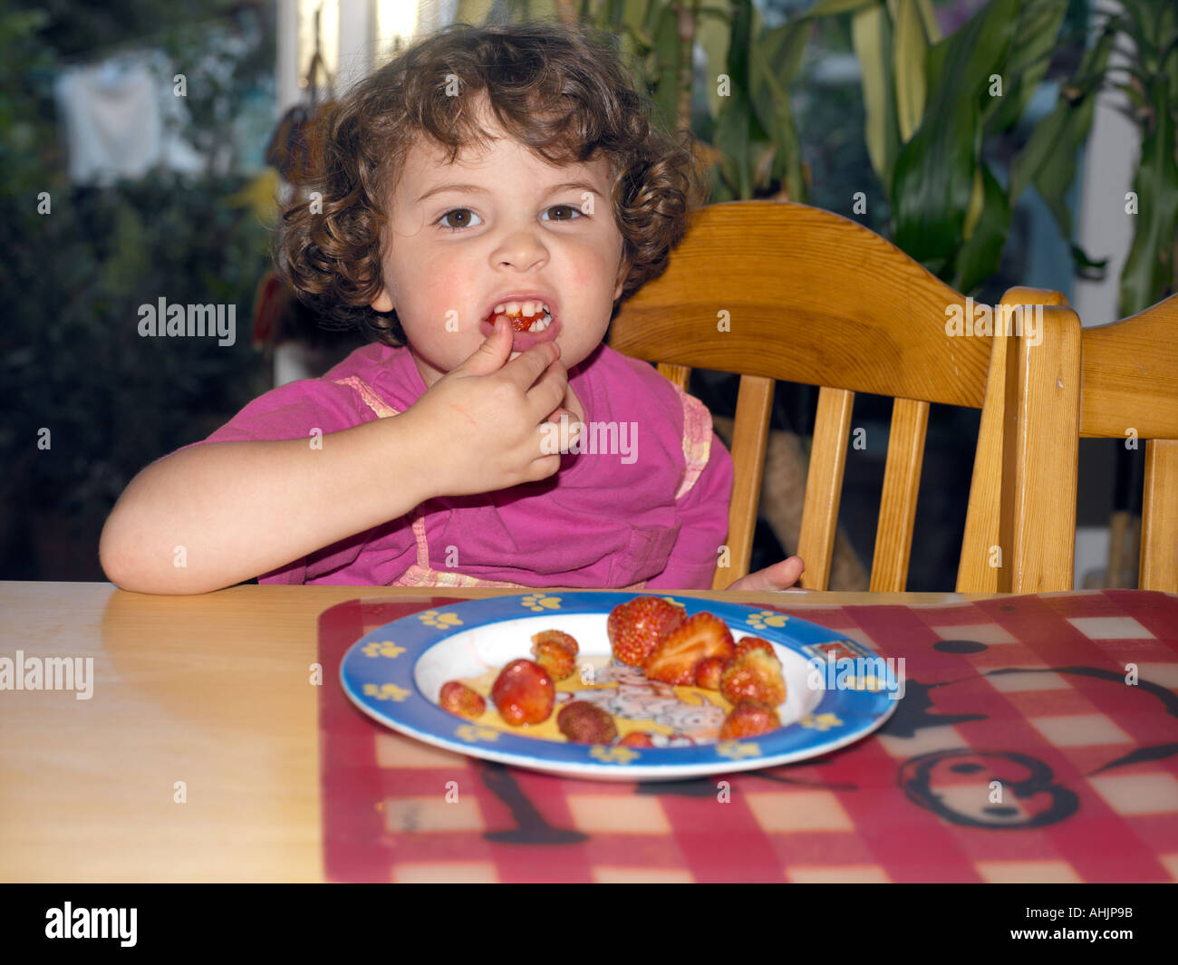 three-year-old-girl-eating-strawberries-stock-photo-alamy