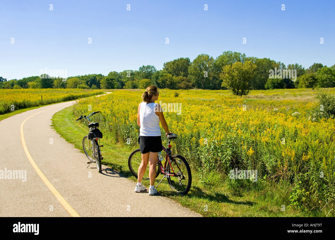 Girl viewing meadow on country bicycle trail Stock Photo - Alamy