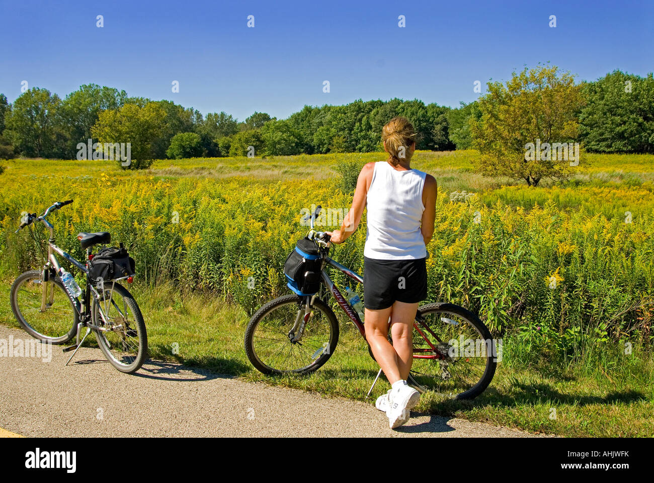 Girl viewing meadow on country bicycle trail Stock Photo - Alamy