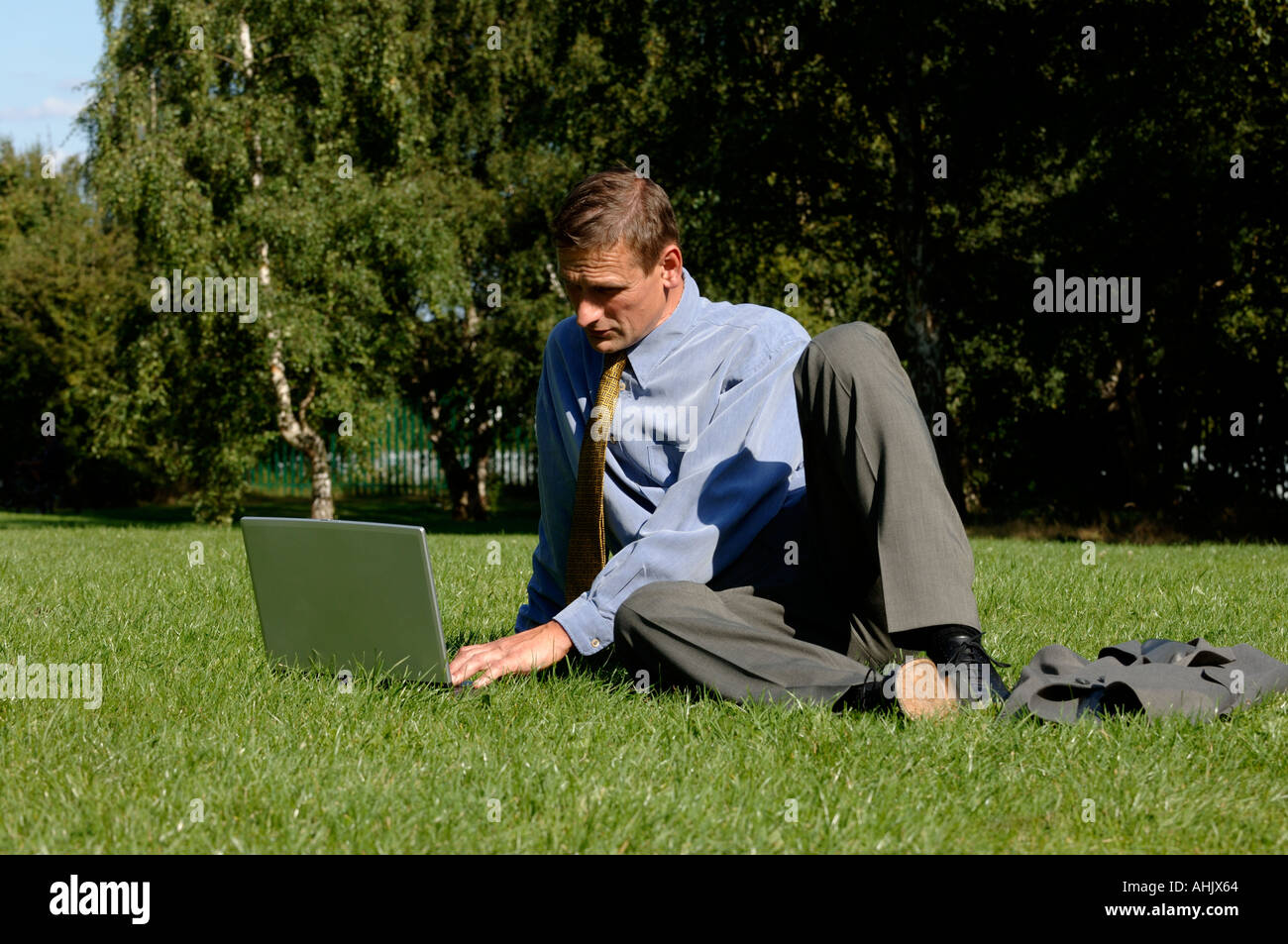 Businessman outdoors using a laptop Stock Photo