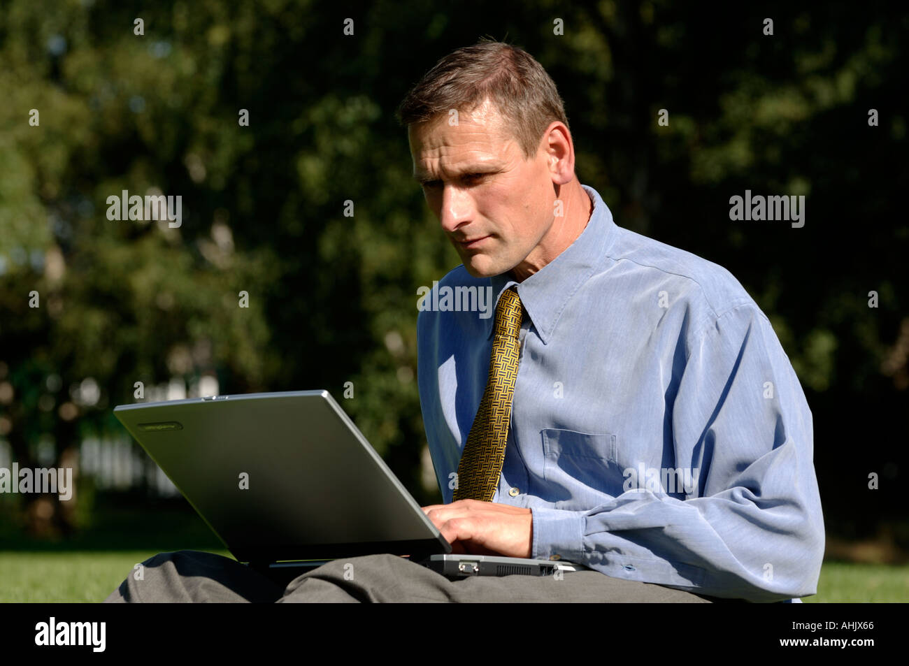Businessman outdoors using a laptop Stock Photo