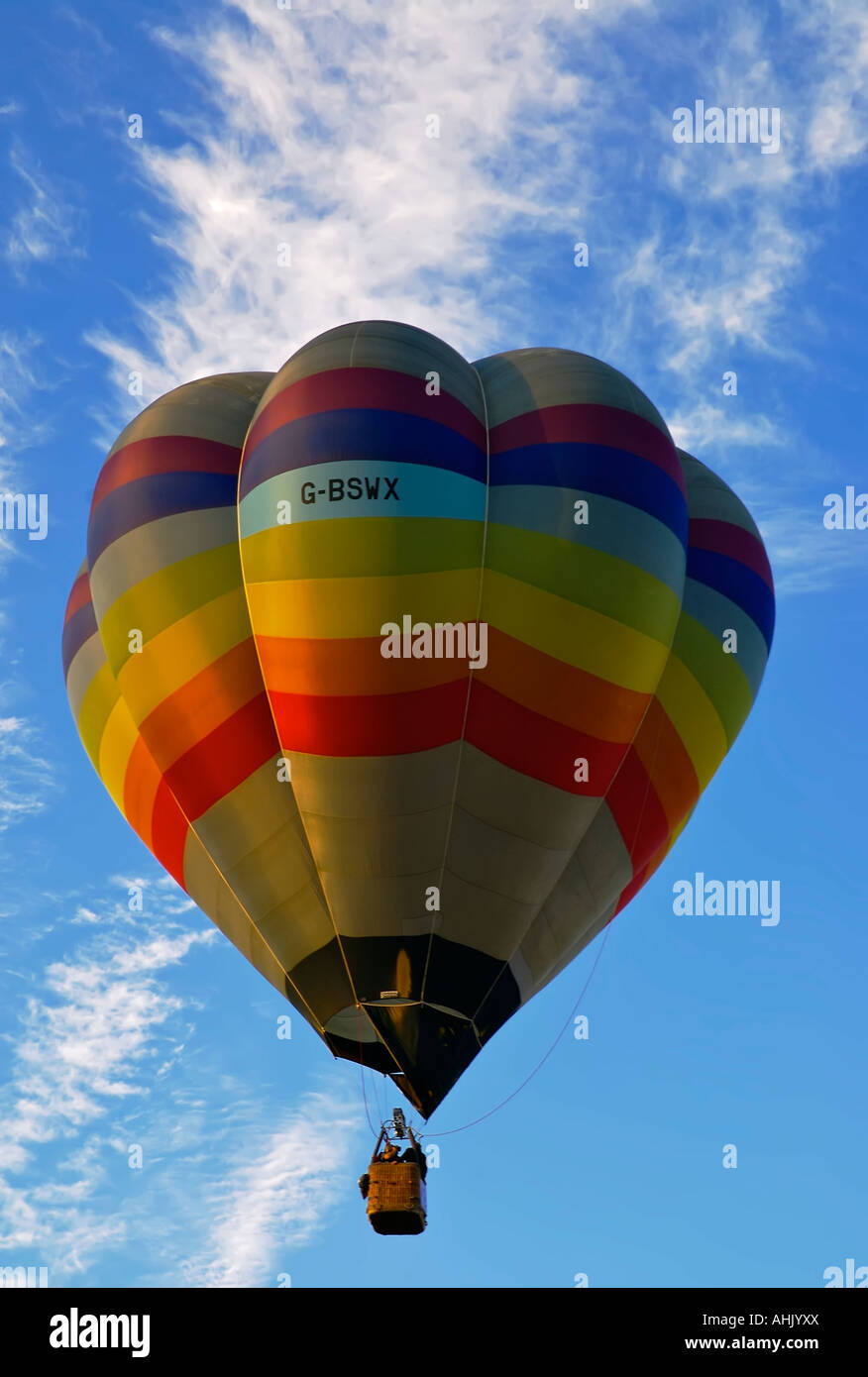 Hot air balloon flying in a blue sky with whispy white clouds Stock ...