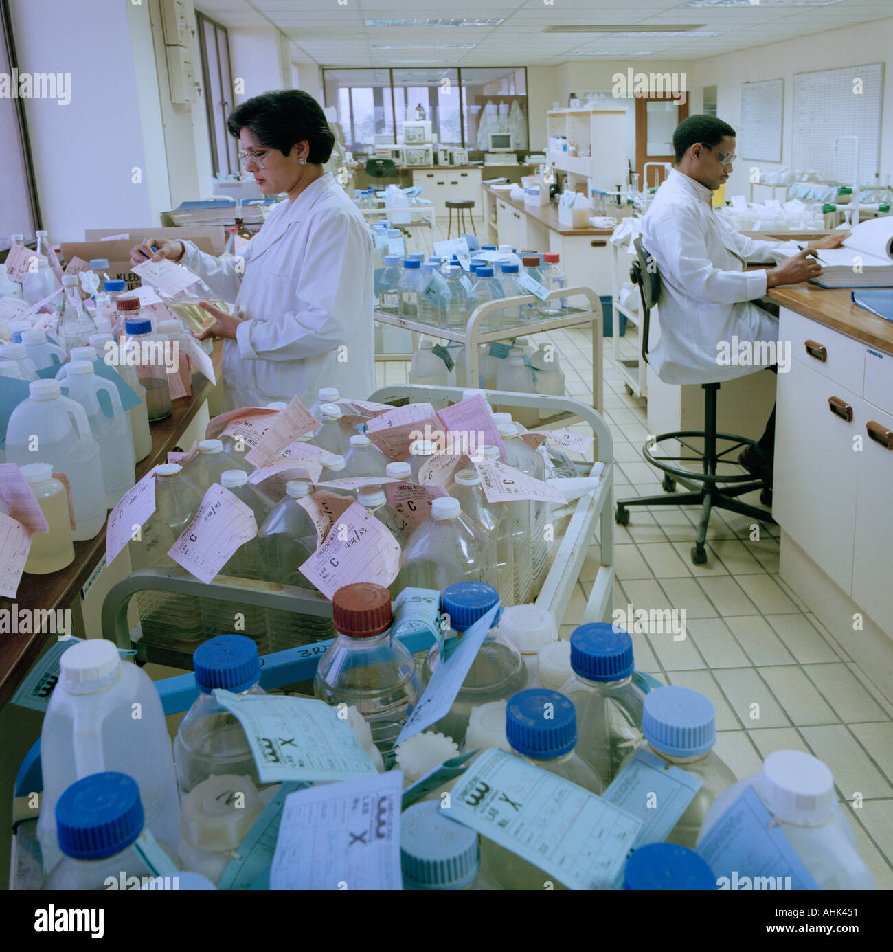Male and female technicians in a water monitoring laboratory sampling public water supplies in