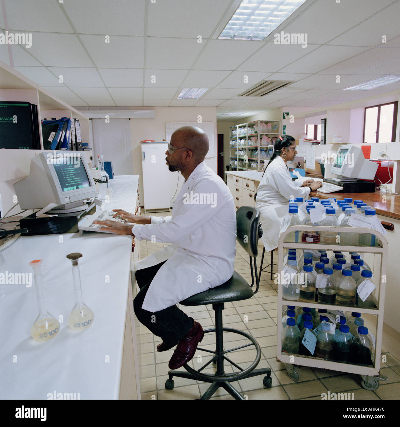 Male and female laboratory technicians monitoring the quality and