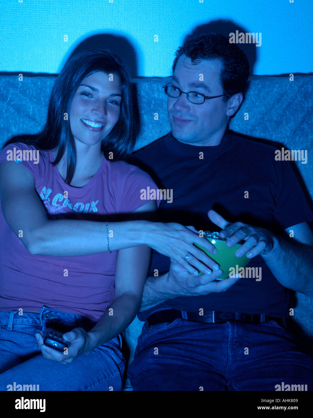 Couple watching TV and eating popcorn Stock Photo