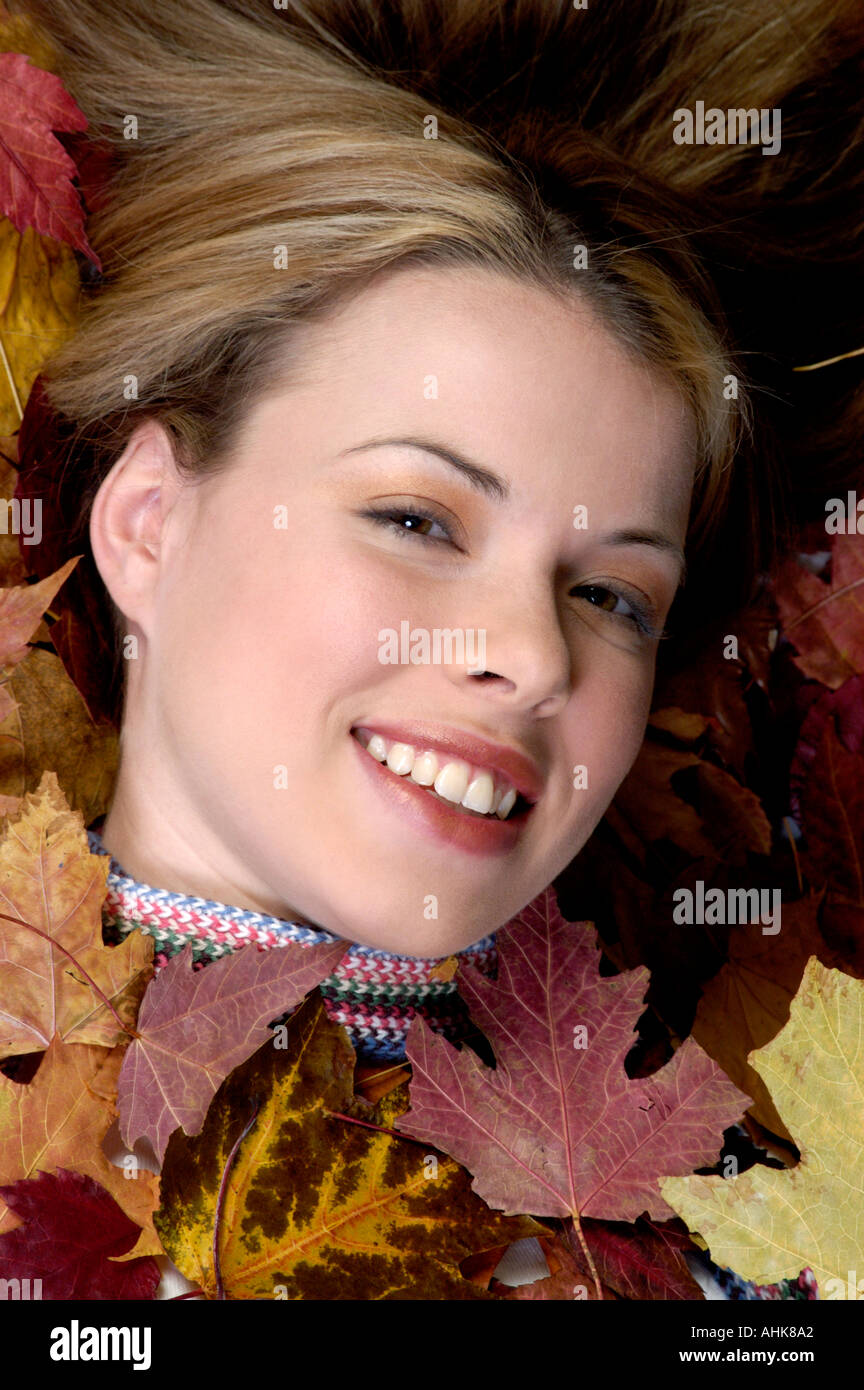 Pretty girl lying down in some fall leaves Stock Photo