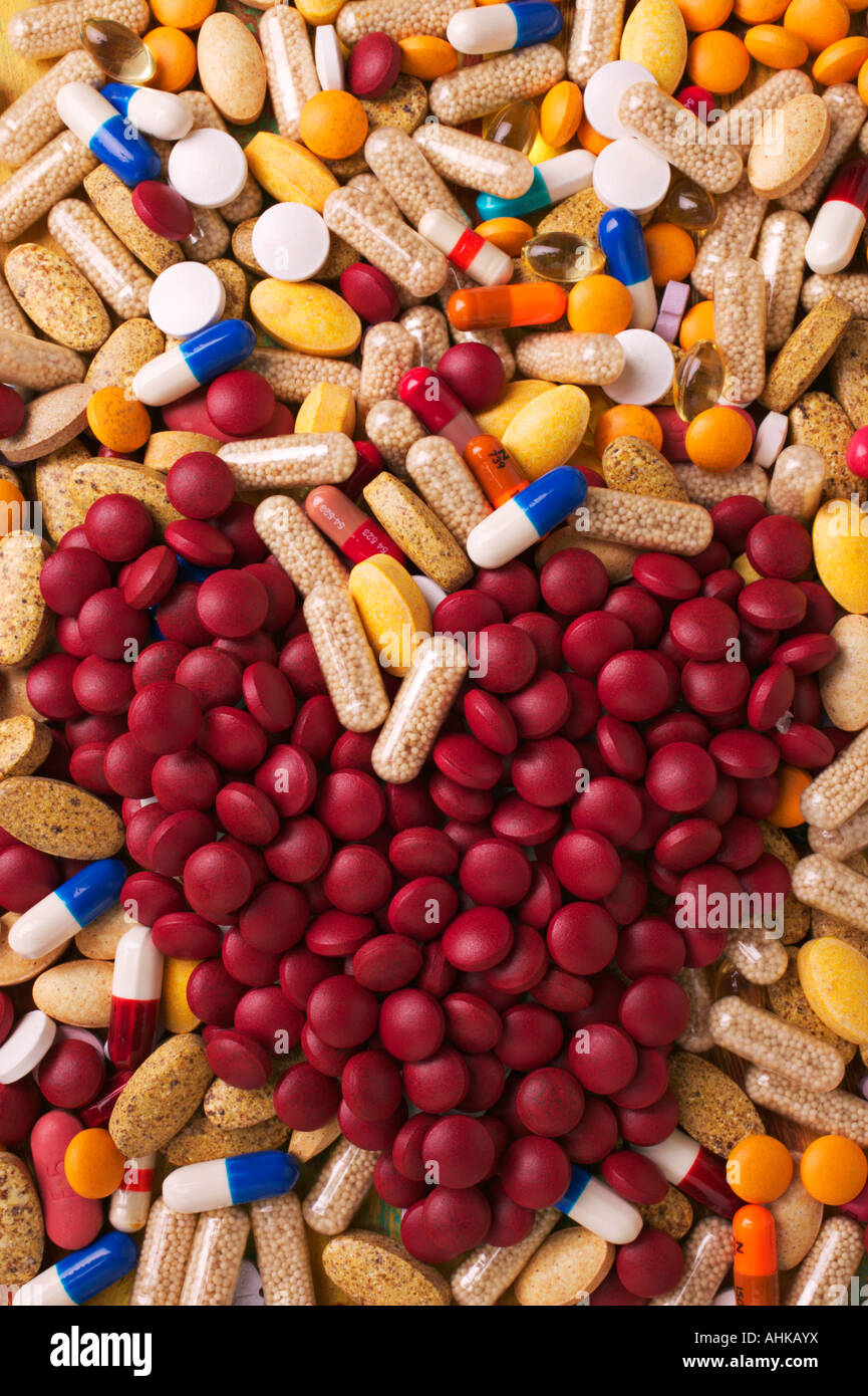 Assorted pills and a pile of red pills in heart shape Stock Photo