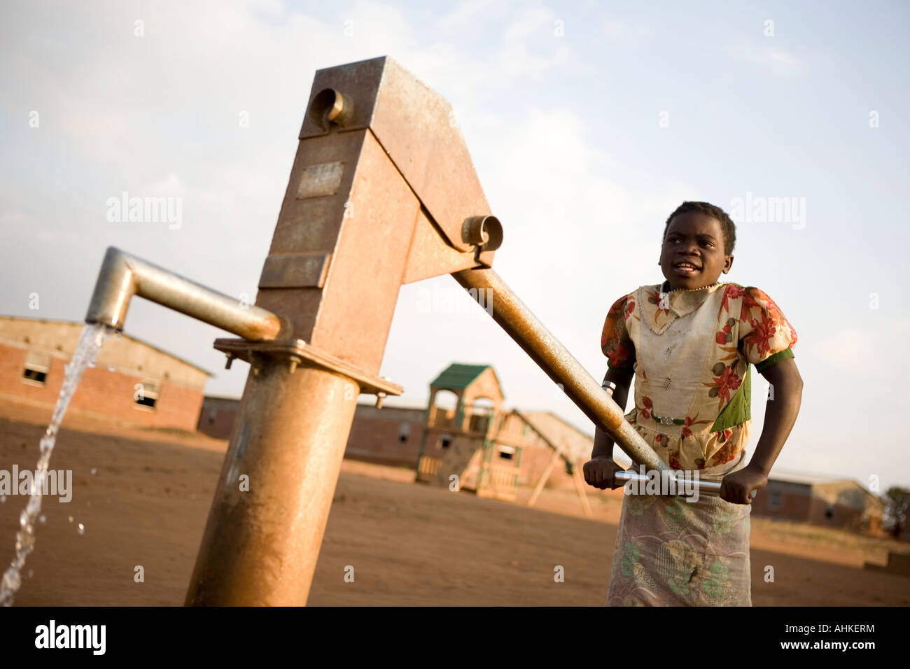 Orphan child drawing water from a well in Malawi, Africa Stock Photo