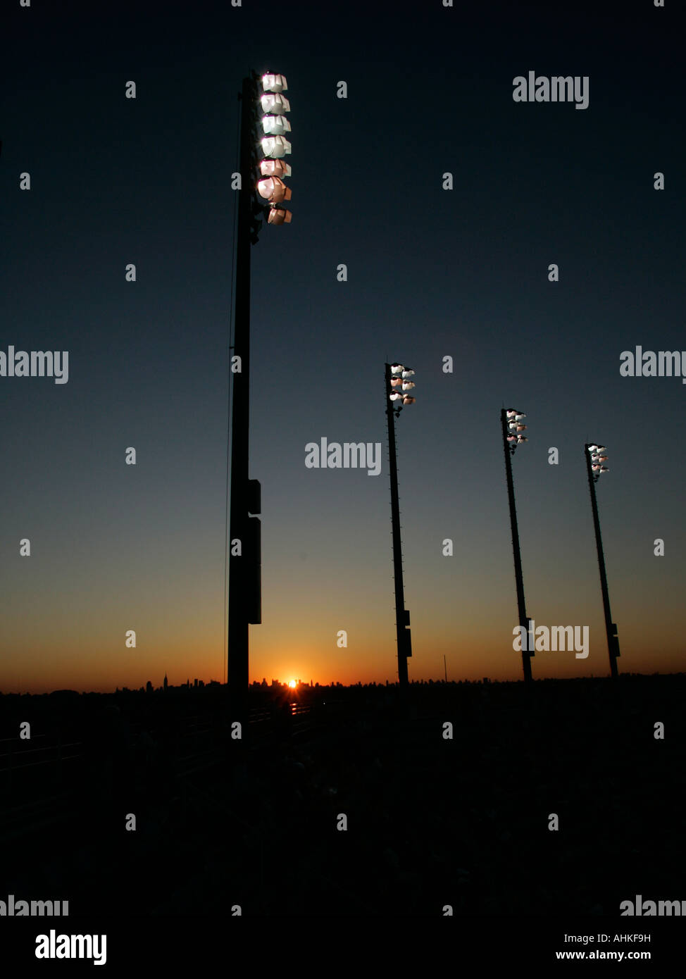 Sun setting behind the floodlights of the Billie Jean National Tennis Center Stock Photo