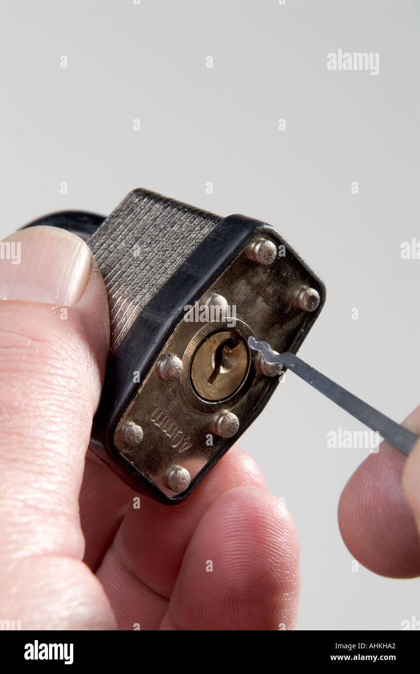 Hand with lock pick opening padlock Stock Photo Alamy