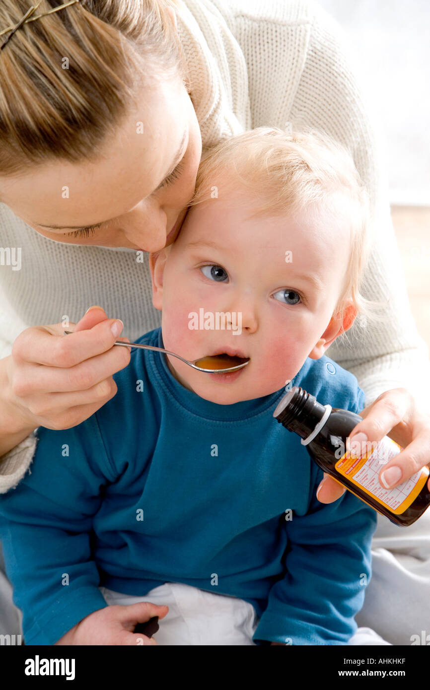 mum giving syrup to her child Stock Photo Alamy