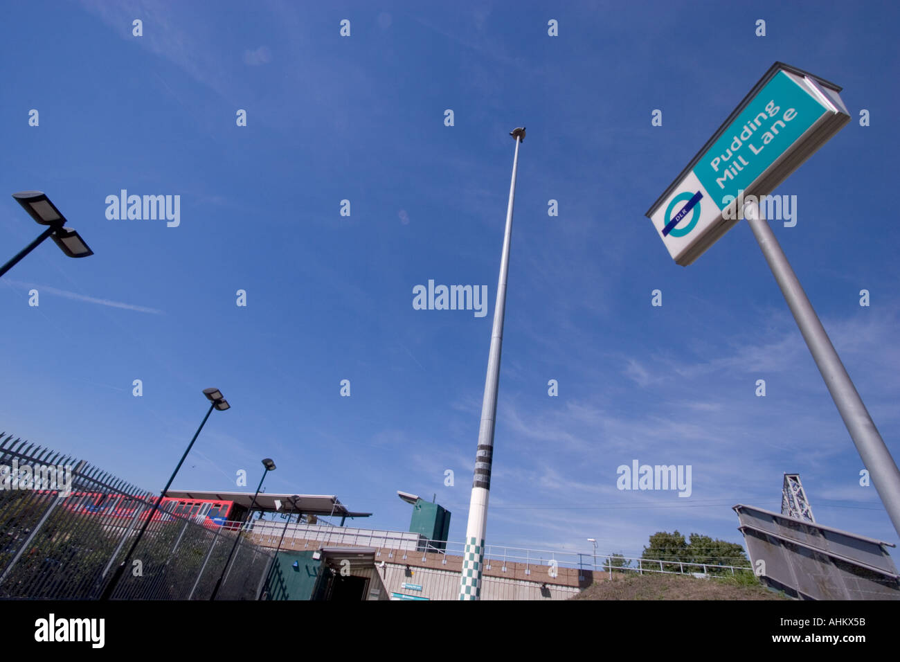 Pudding mill lane DLR dockland light railway station sign with train in