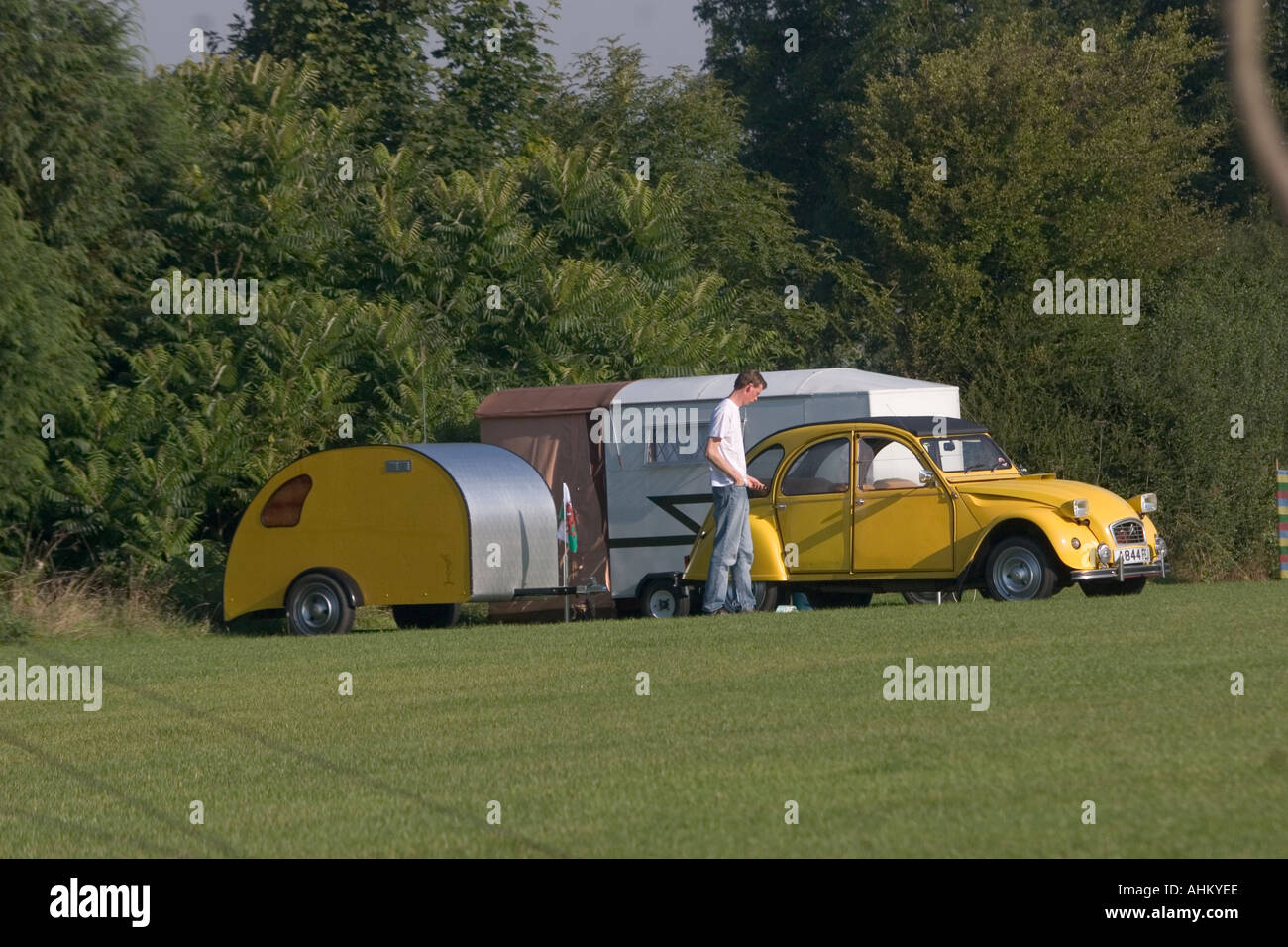 Yellow Citroen deux chevaux 2cv with matching camper trailer Stock Photo