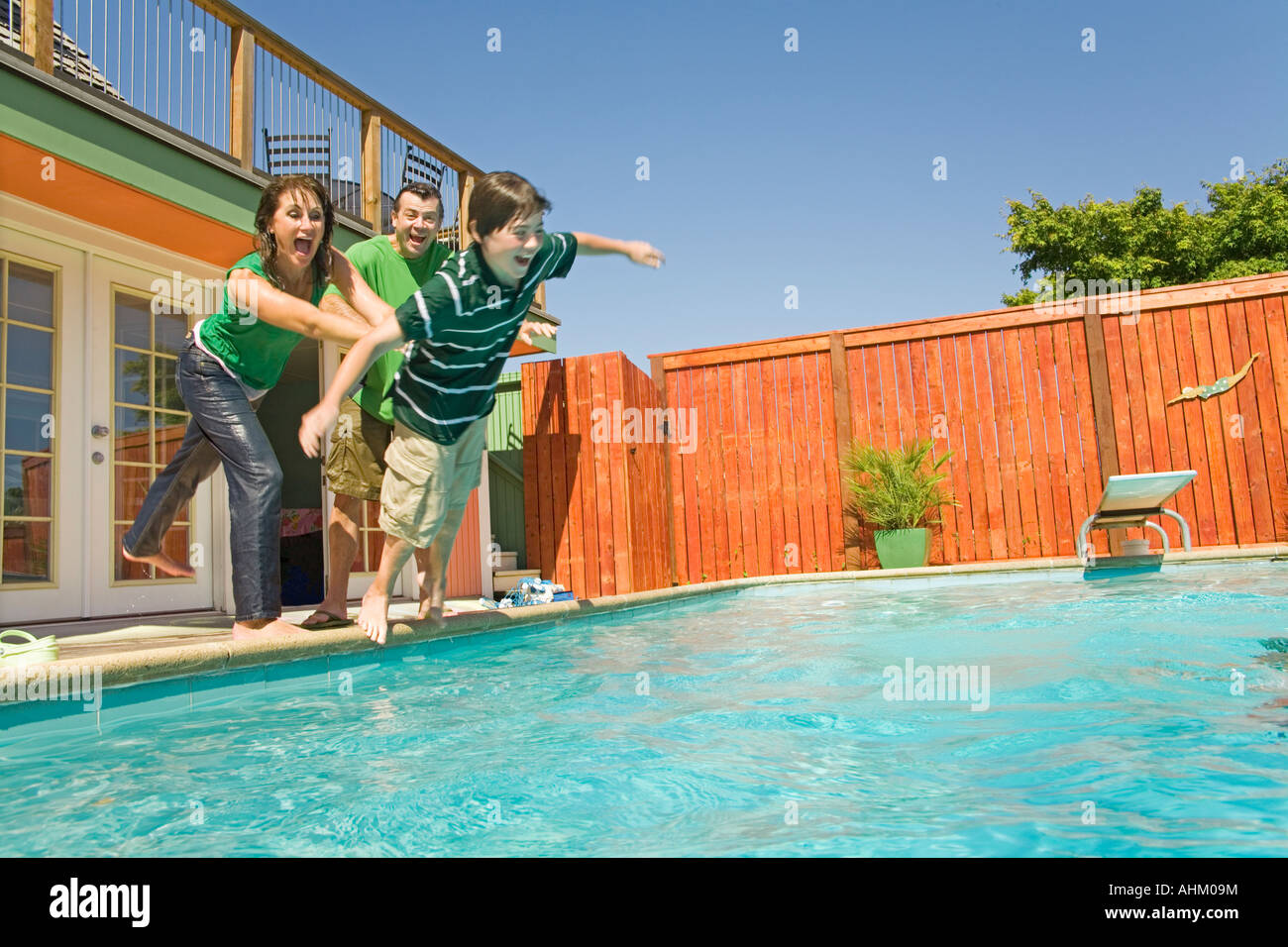 Family jumping into swimming pool Stock Photo Alamy