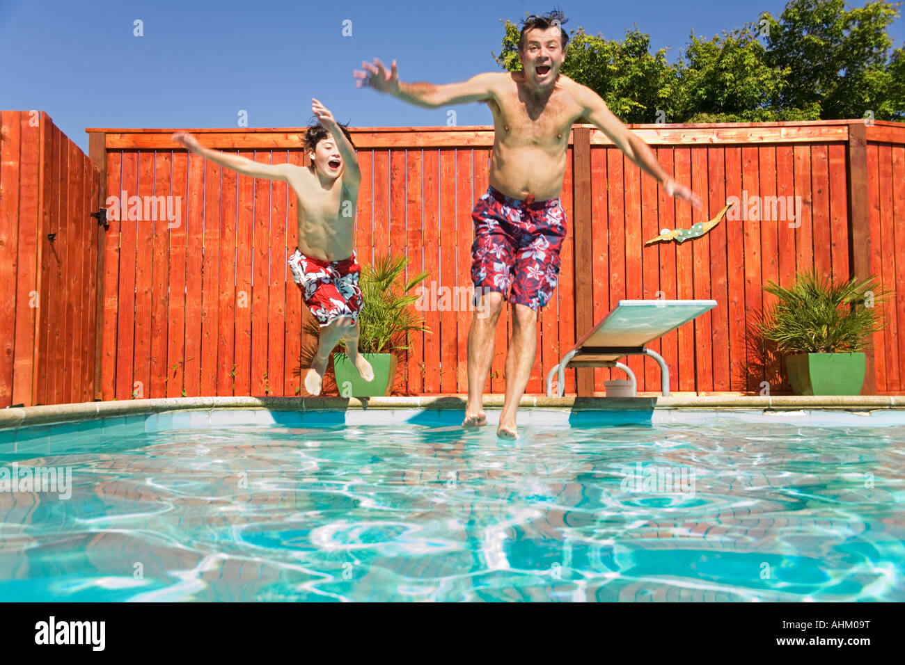 Father and son jumping into swimming pool Stock Photo Alamy