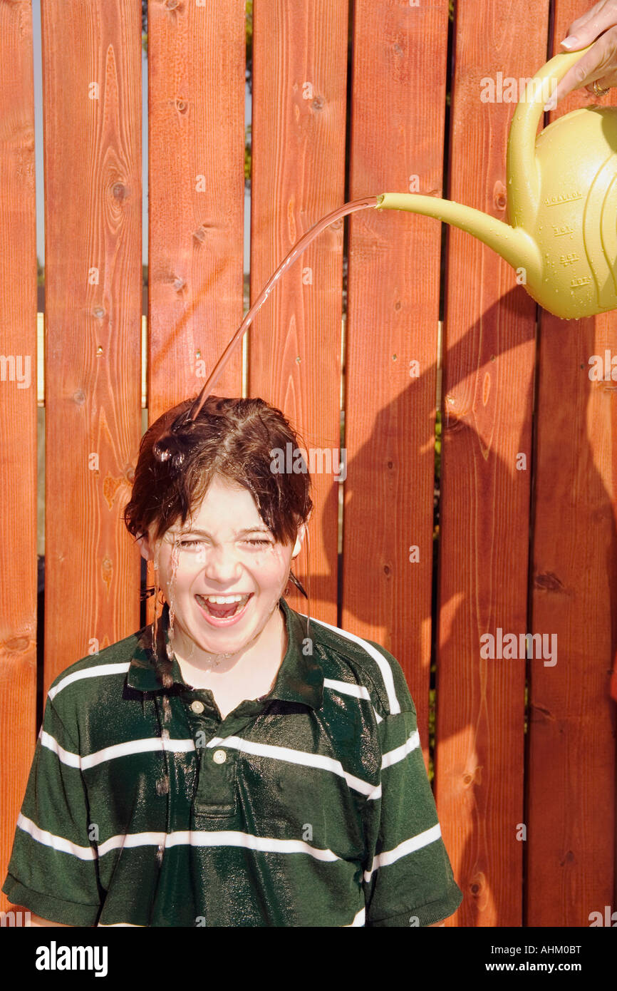 Watering can pouring over boy’s head Stock Photo Alamy