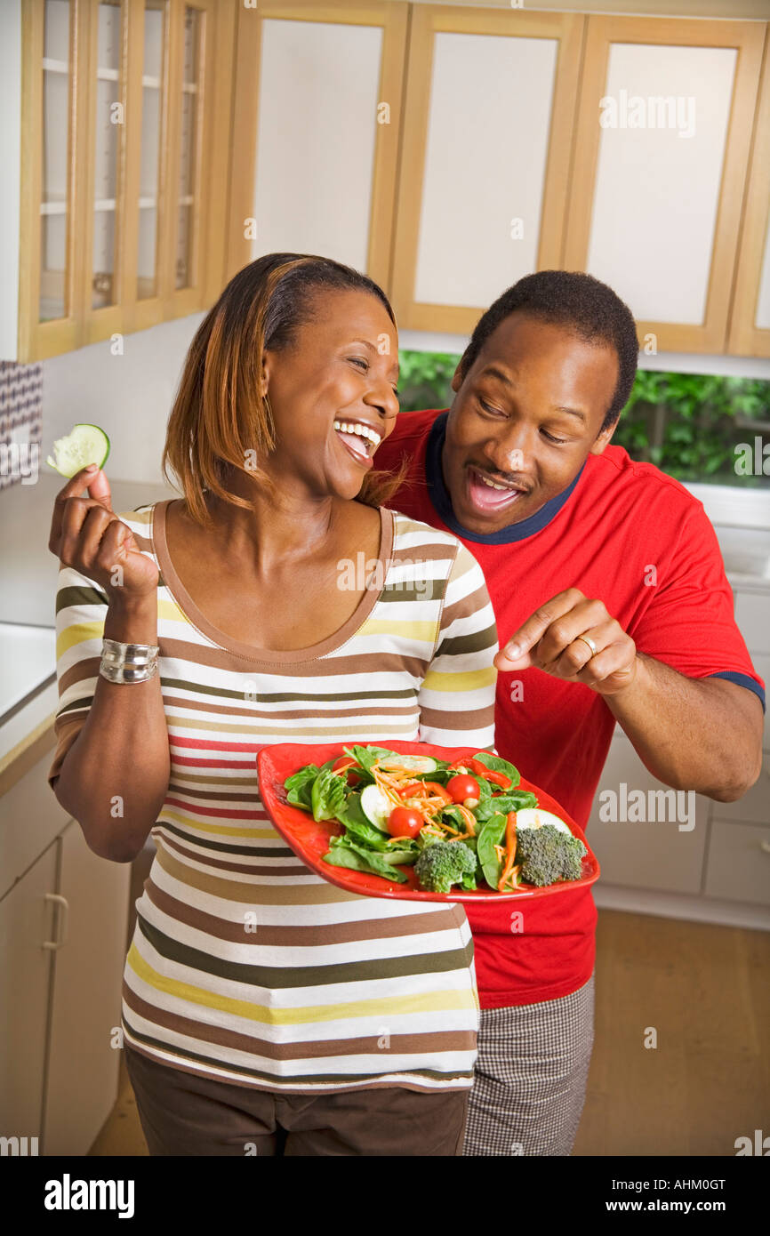 African couple with vegetable plate in kitchen Stock Photo