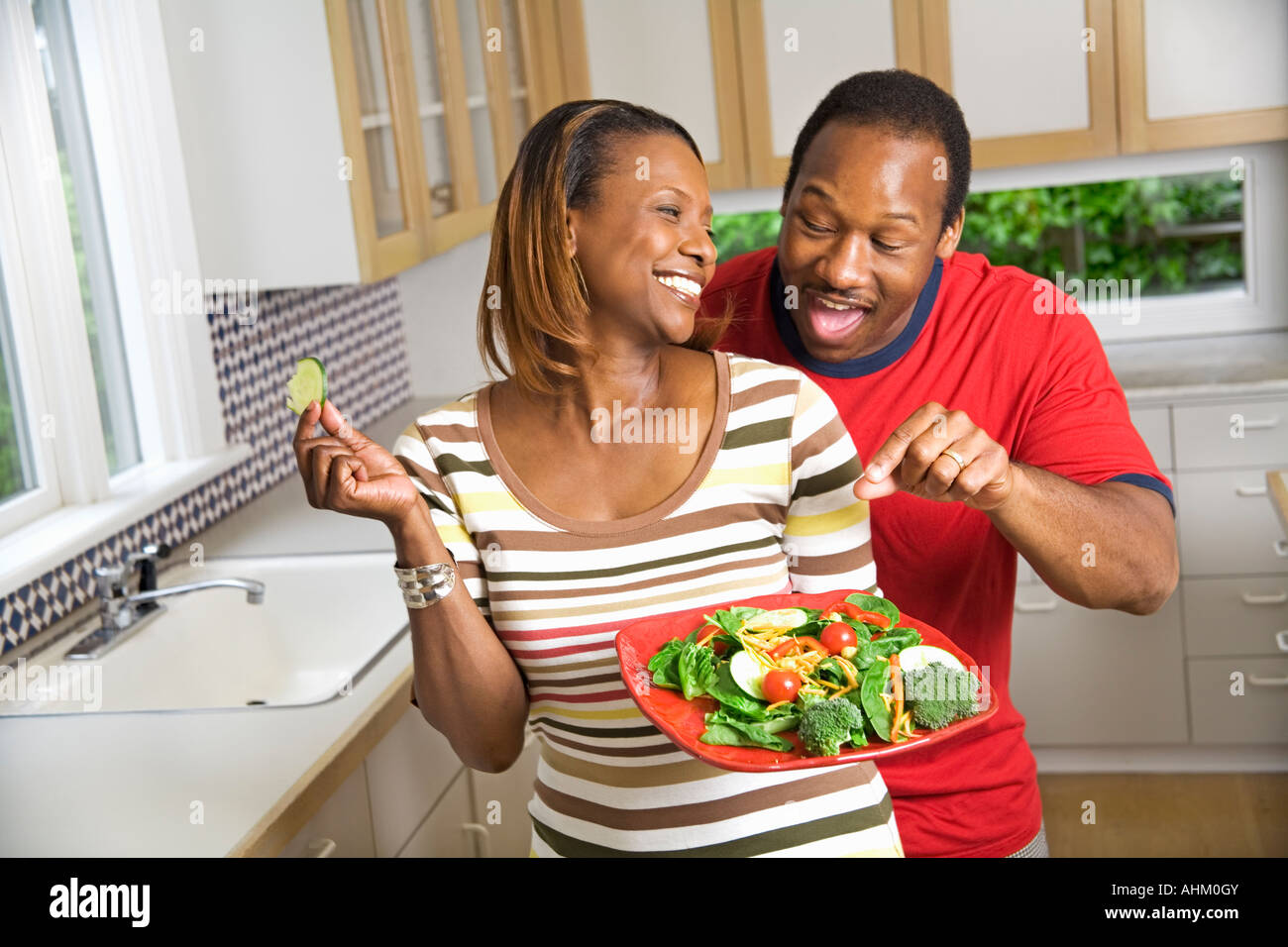 African couple with vegetable plate in kitchen Stock Photo
